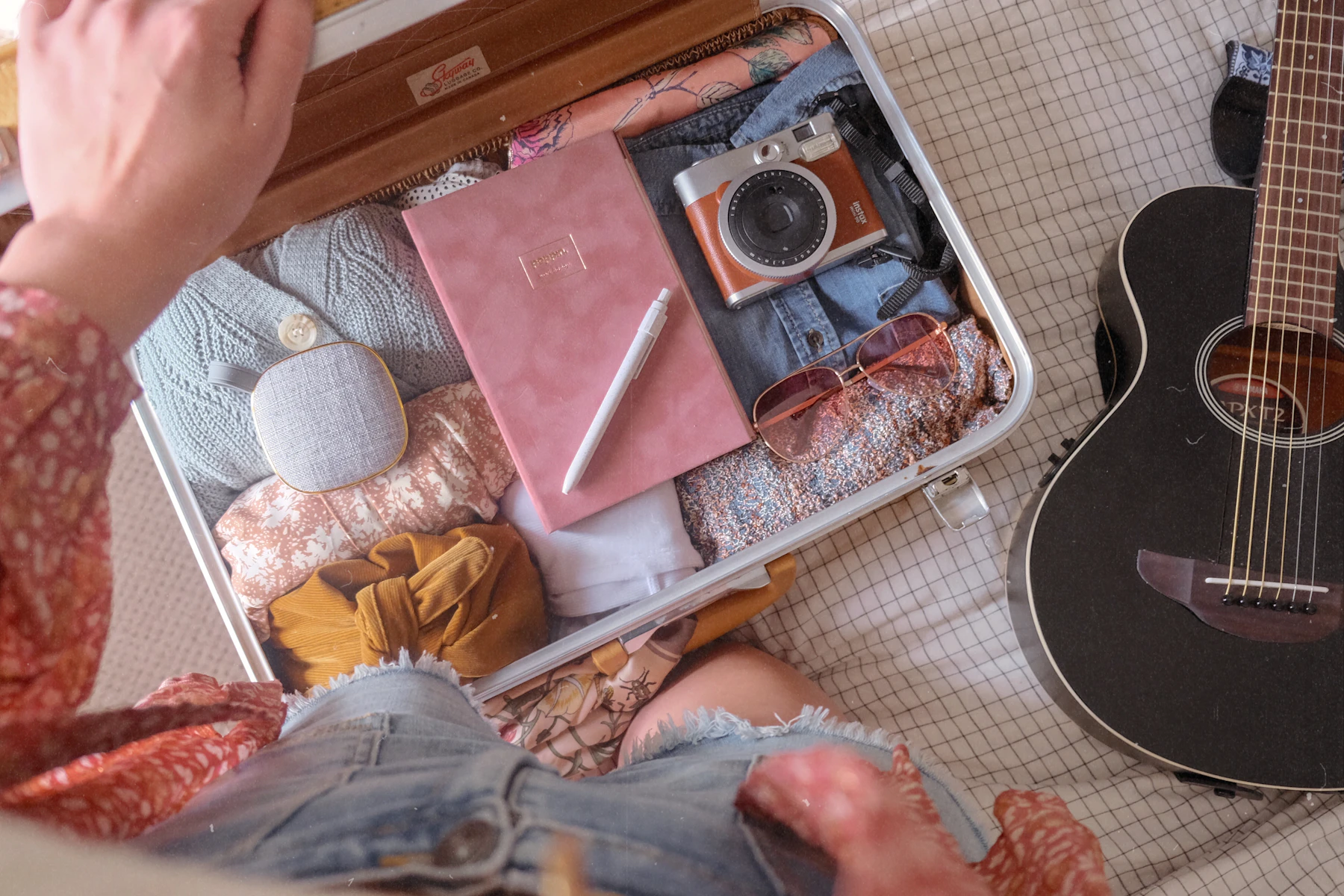 Woman packing clothes into an open suitcase for a journey